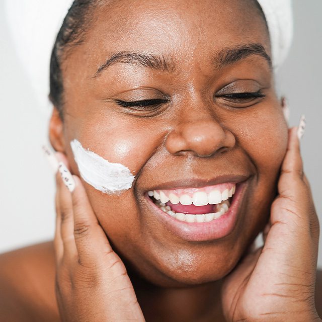 woman applying moisturizer to her face