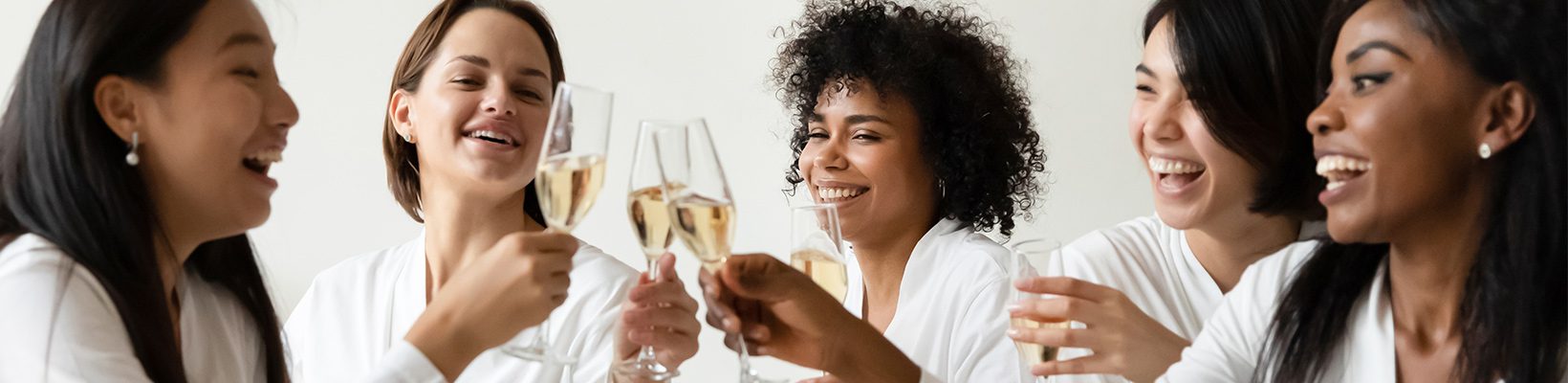 women toasting with champagne in bath robes