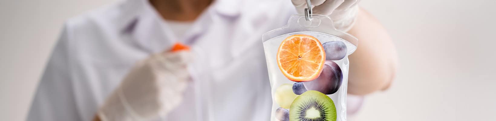 nurse holding an IV bag full of fruit to symbolize vitamin injections