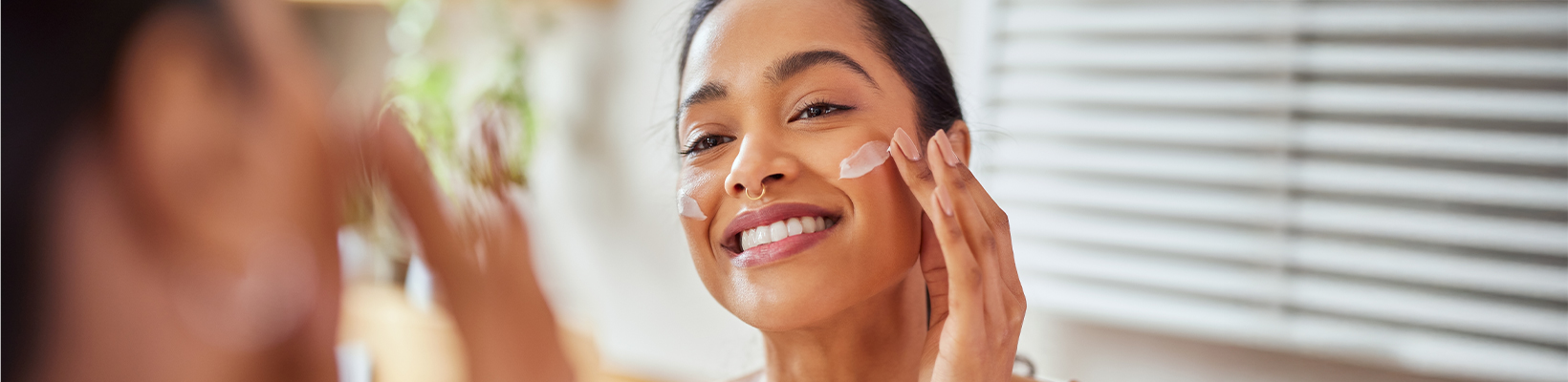 woman applying moisturizer on her face